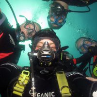 Dive Buddies pose for a group selfie underwater