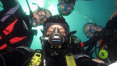 Dive Buddies pose for a group selfie underwater