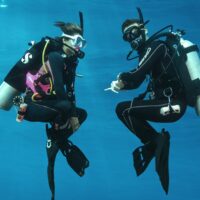 Two scuba divers practicing a hover as part of the PADI Peak Performance Buoyancy course