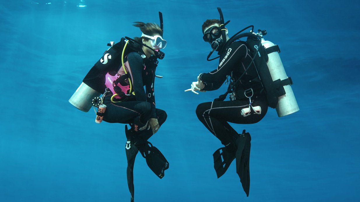Two scuba divers practicing a hover as part of the PADI Peak Performance Buoyancy course