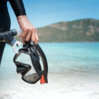 a diver with a scuba mask on the beach