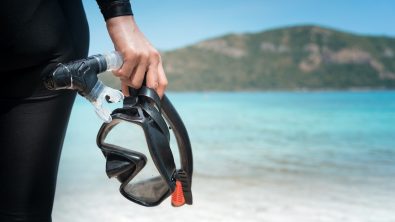 a diver with a scuba mask on the beach