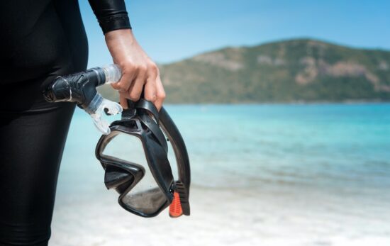 a diver with a scuba mask on the beach