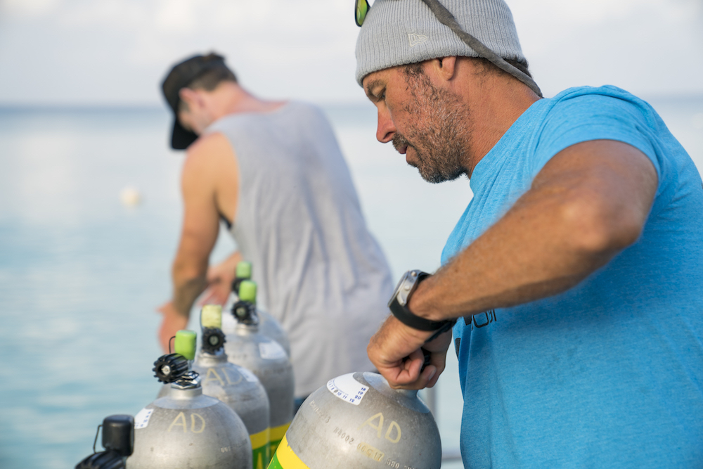 a padi divemaster handles a scuba tank