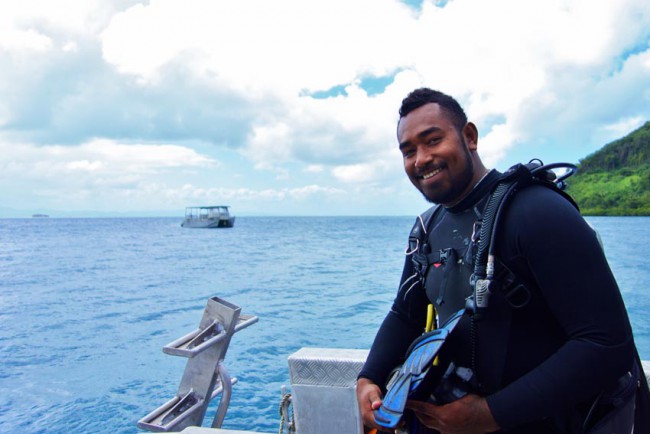 a divemaster smiles and relaxes on a boat