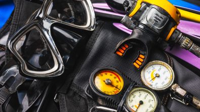 A dive mask and a regulator laid on a BCD and fins