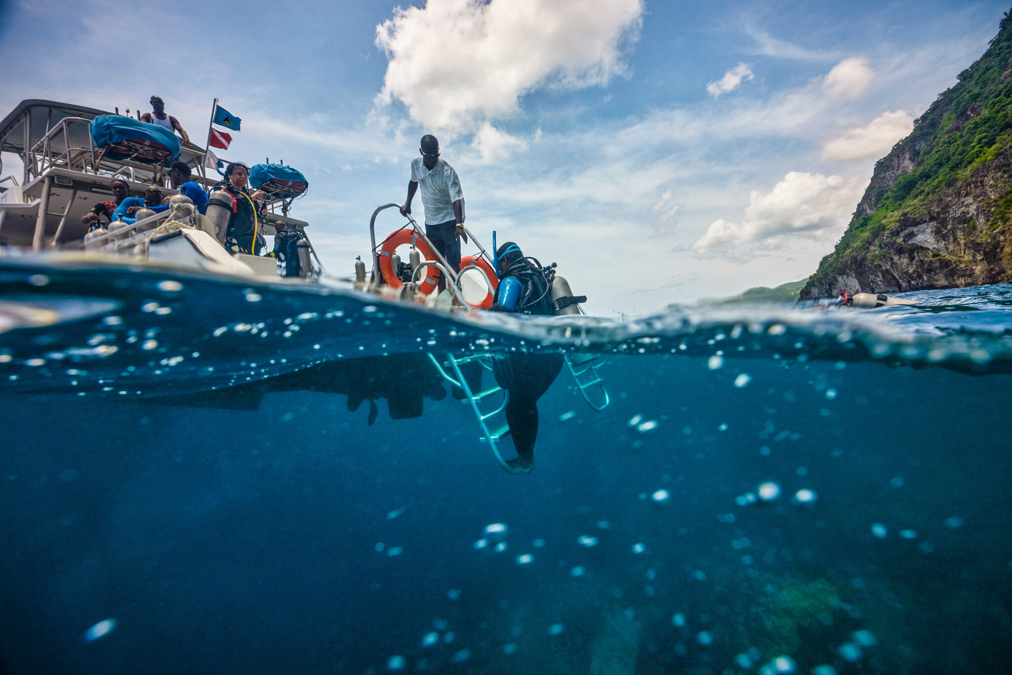 Scuba diver exiting the water, back on the dive boat