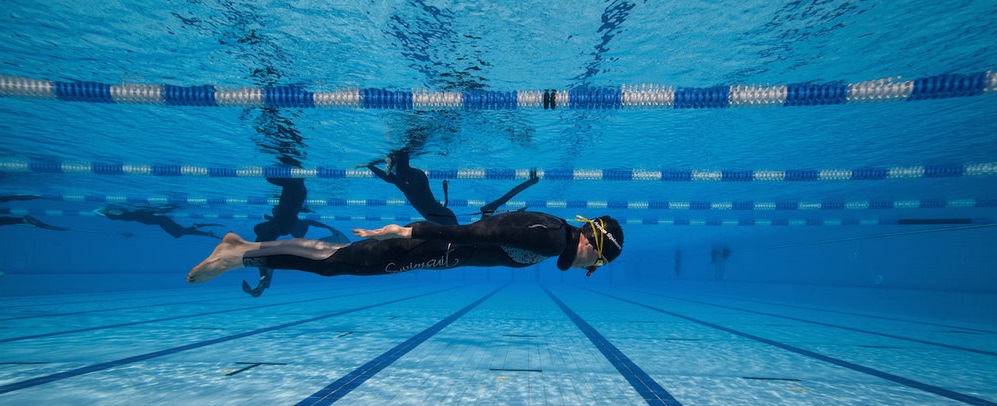 Freediver practicing Dynamic apnea in a pool.