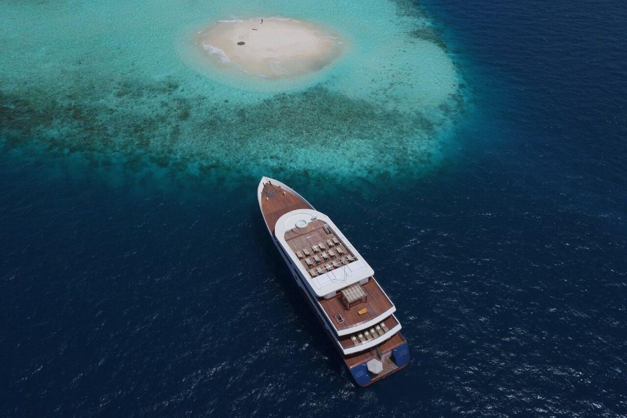 liveaboard anchored by a small sandy island