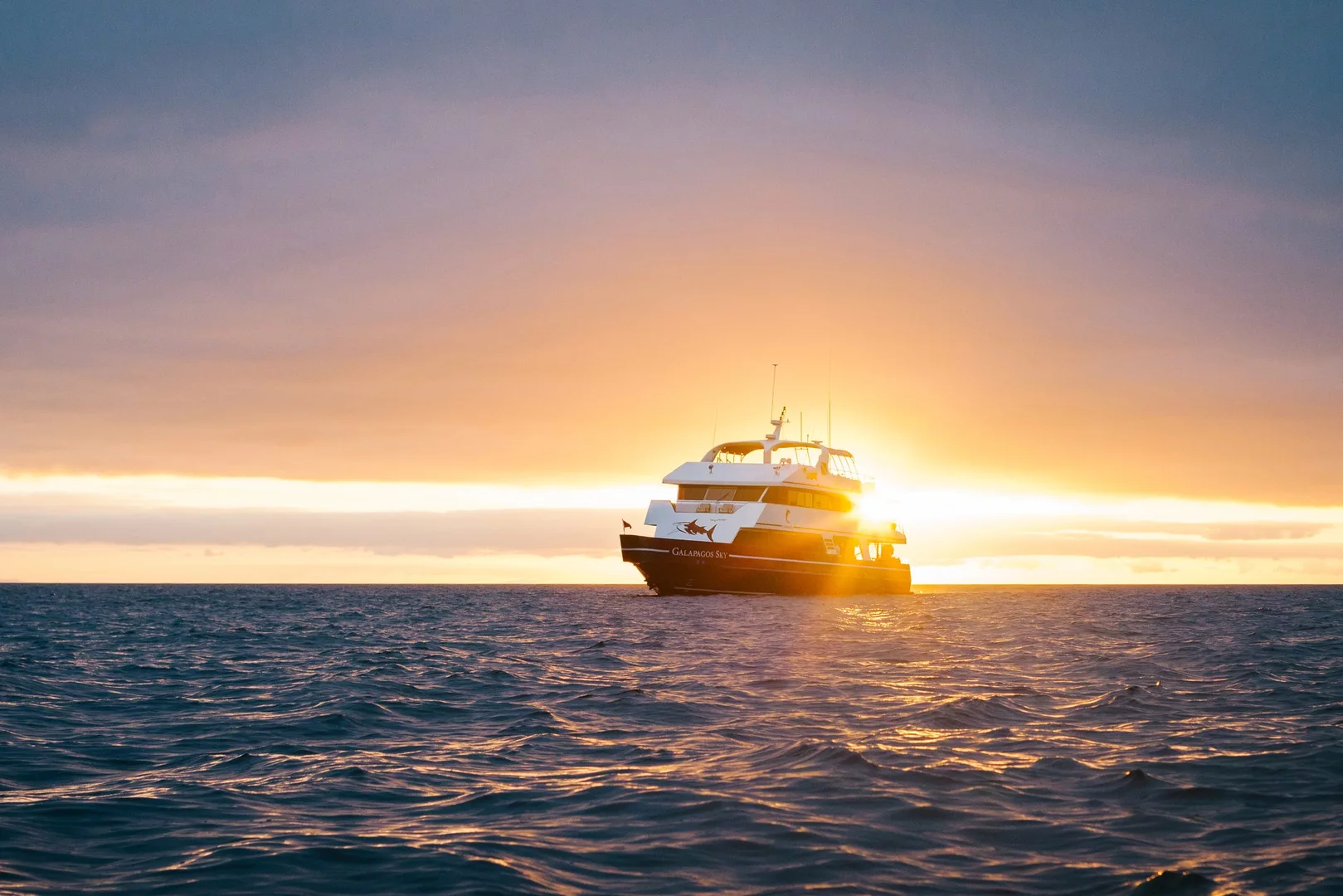 Galapagos Sky liveaboard on the water during sunset