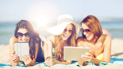 Friends on the beach with tablets from shutterstock