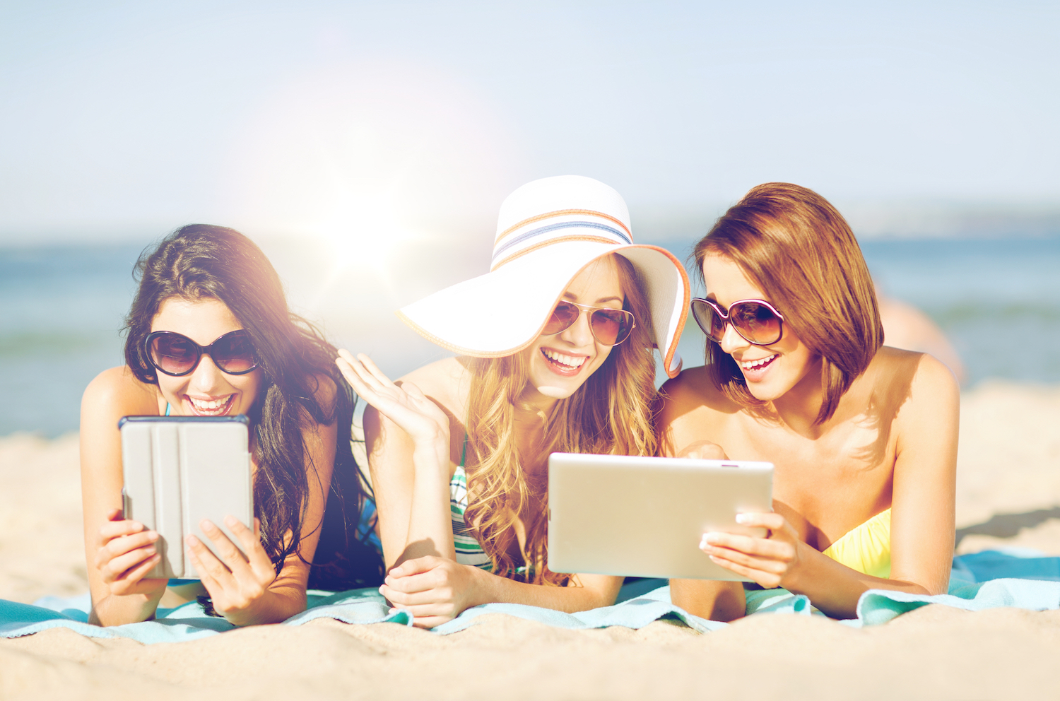 Friends on the beach with tablets for eLearning