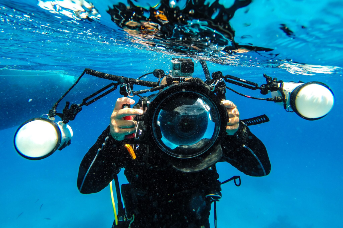 Unterwasserfotograf mit Kameraausrüstung.