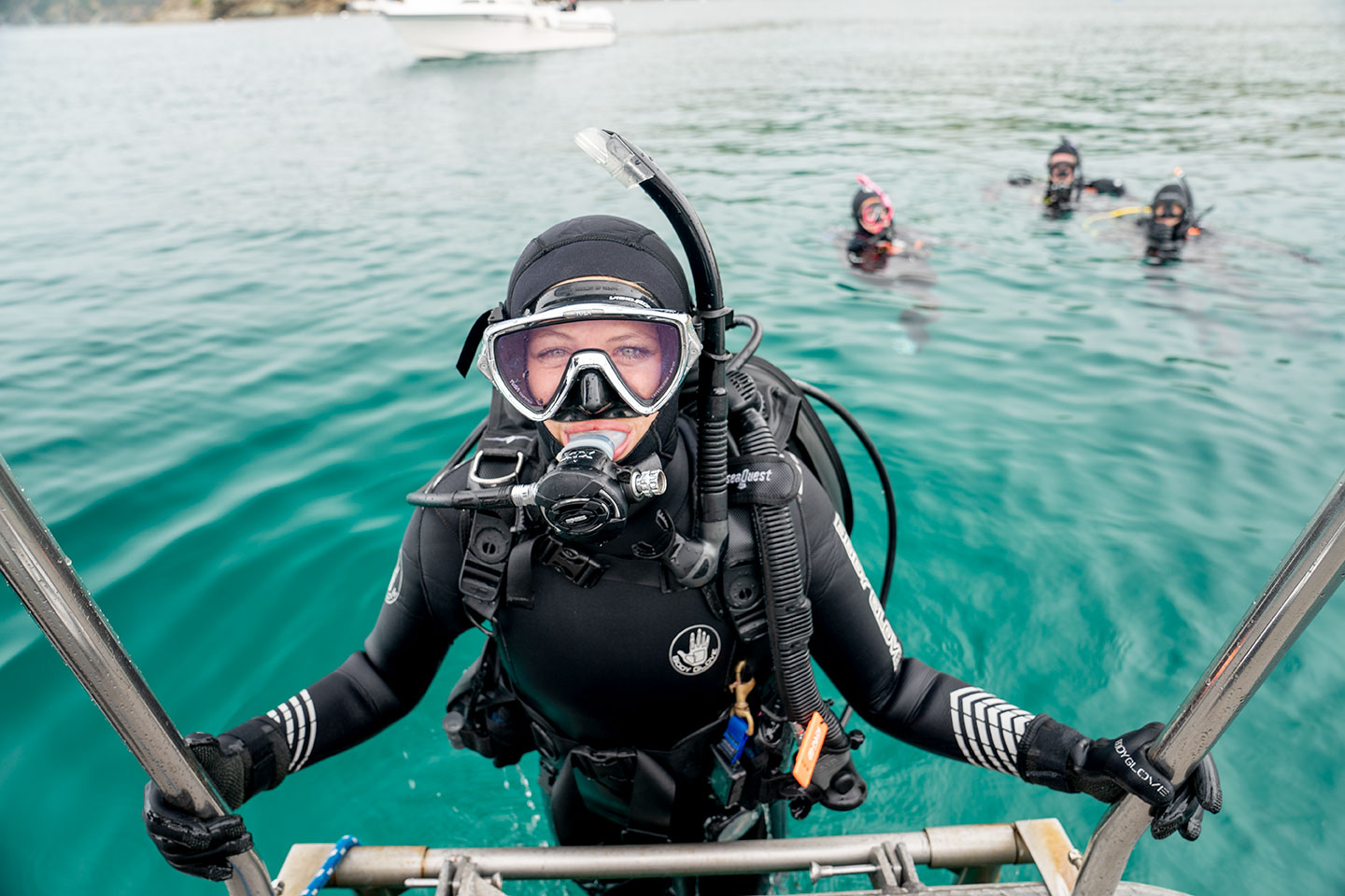 A diver exiting the water wearing a scuba mask, which is specifically designed for scuba diving