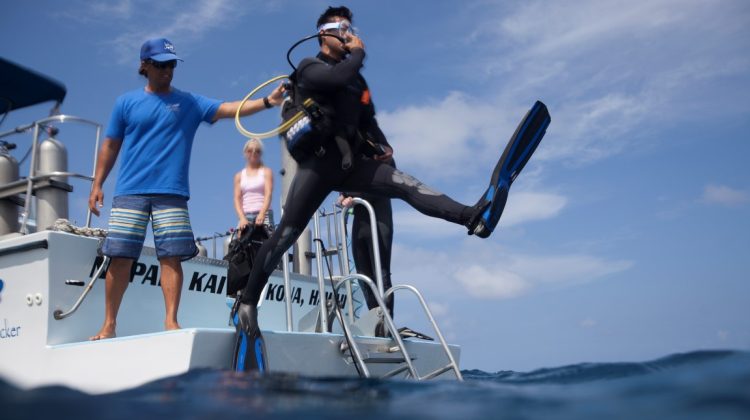 Diver entering in the water from a boat using the giant stride technique