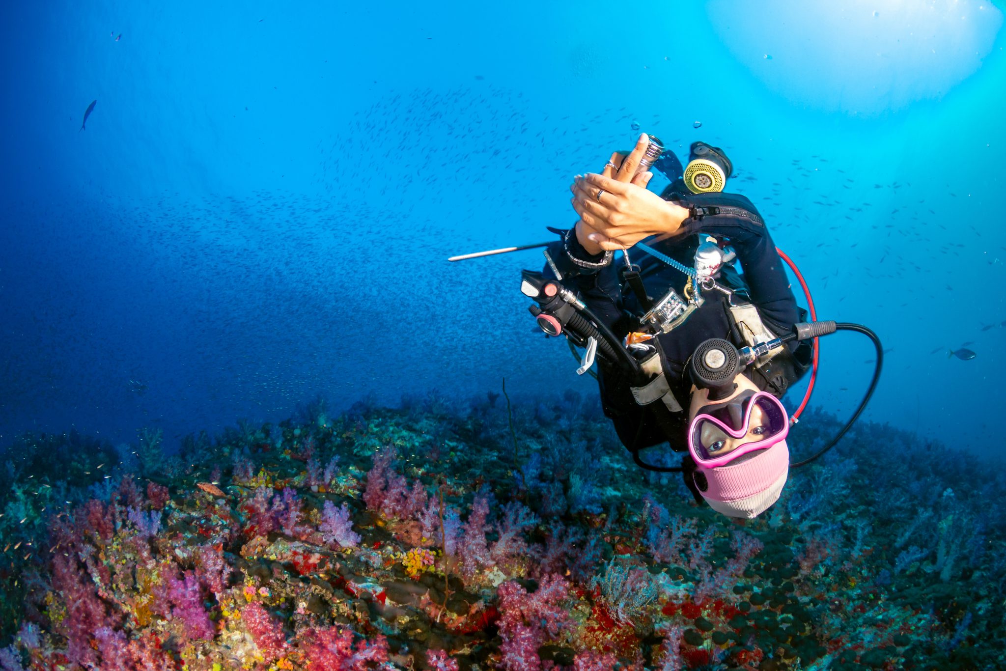 A scuba diver swimming on a colorful coral reef and enjoying the peacefulness brought by underwater world meditation