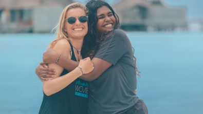two female divers hug each other in the Maldives