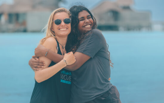 two female divers hug each other in the Maldives