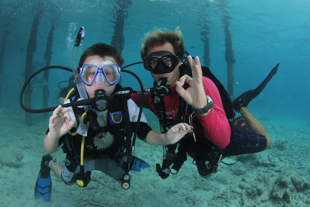 a young scuba diver and adult diver underwater in Bonaire