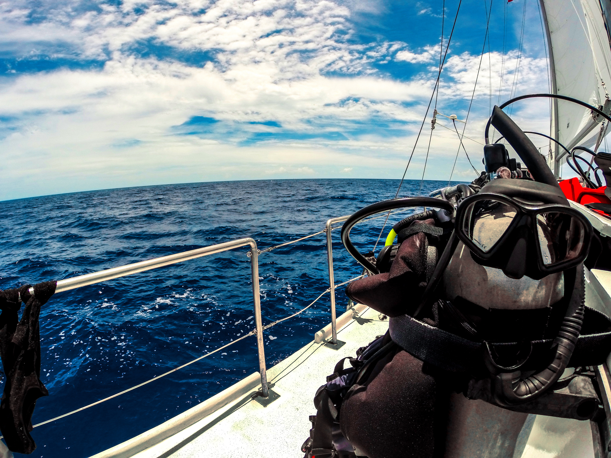 A scuba mask and BCD resting on the top of a tank while traveling to a dive site on a dive boat during a vacation