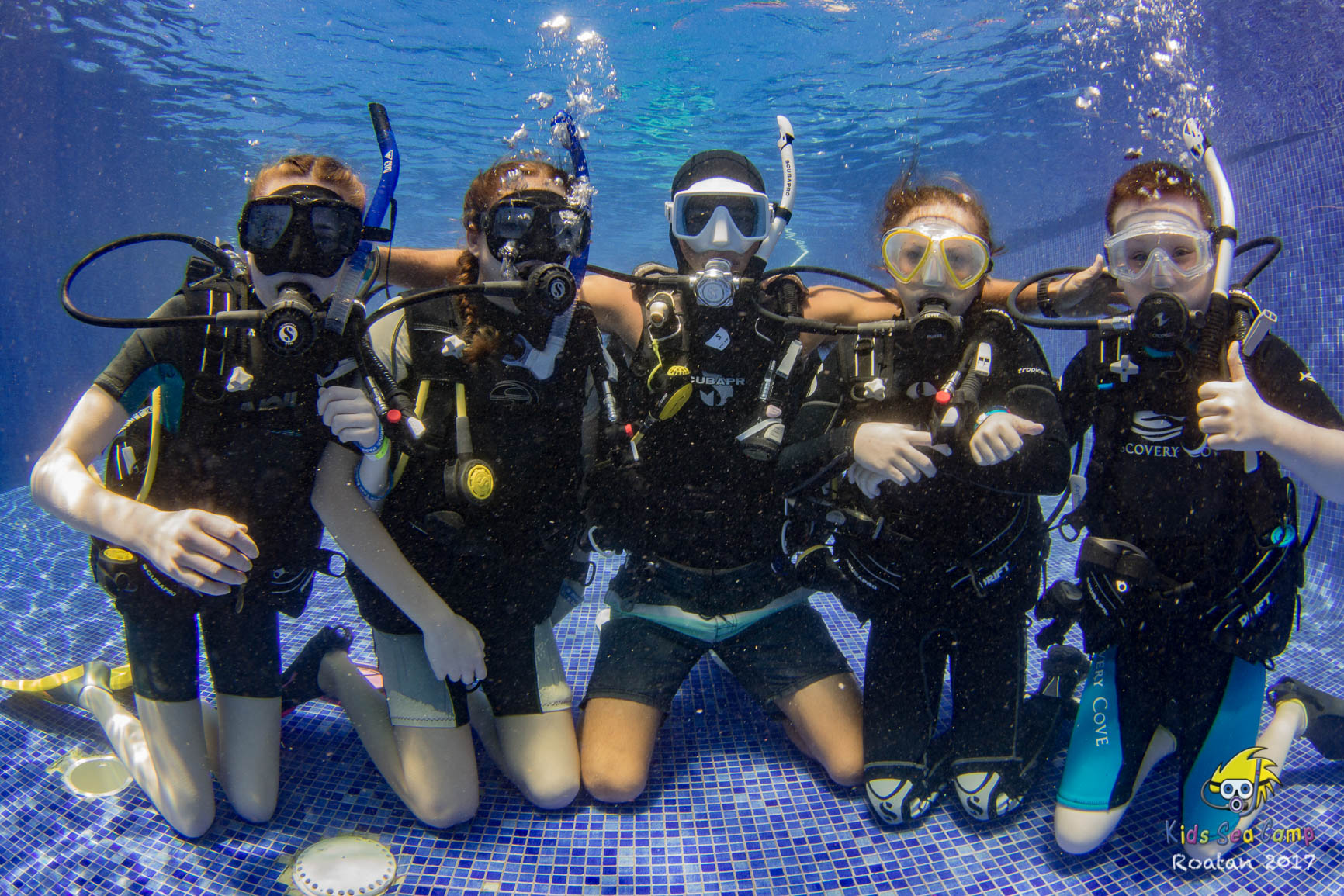 kids scuba diving in a pool