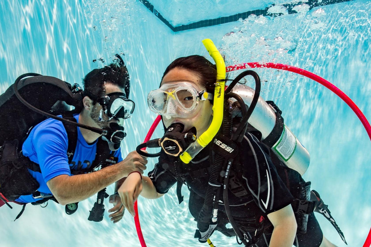 Young scuba diver completing a course in pool setting.