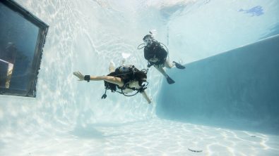 two divers in a pool practicing buoyancy