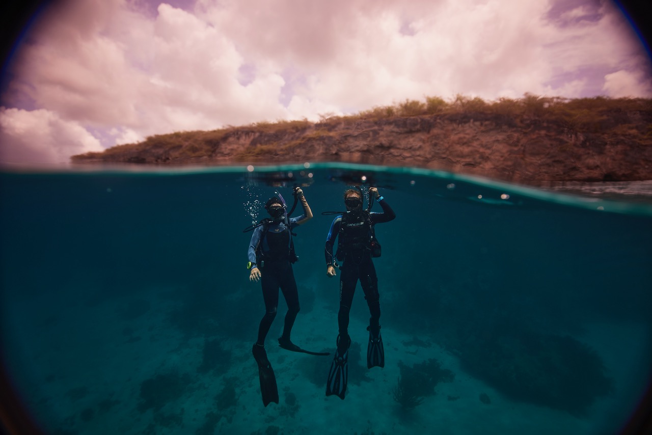 two divers descend underwater in Curacao