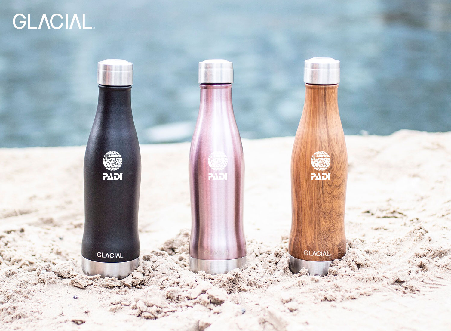 Glacial Bottles in the sand, refillable bottles sold in the PADI LOVES Marketplace