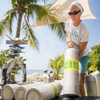 Diving instructor lifting tanks