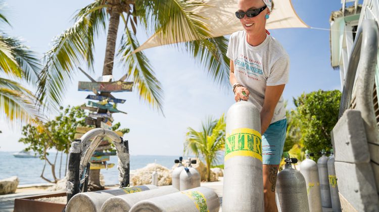 Diving instructor lifting tanks