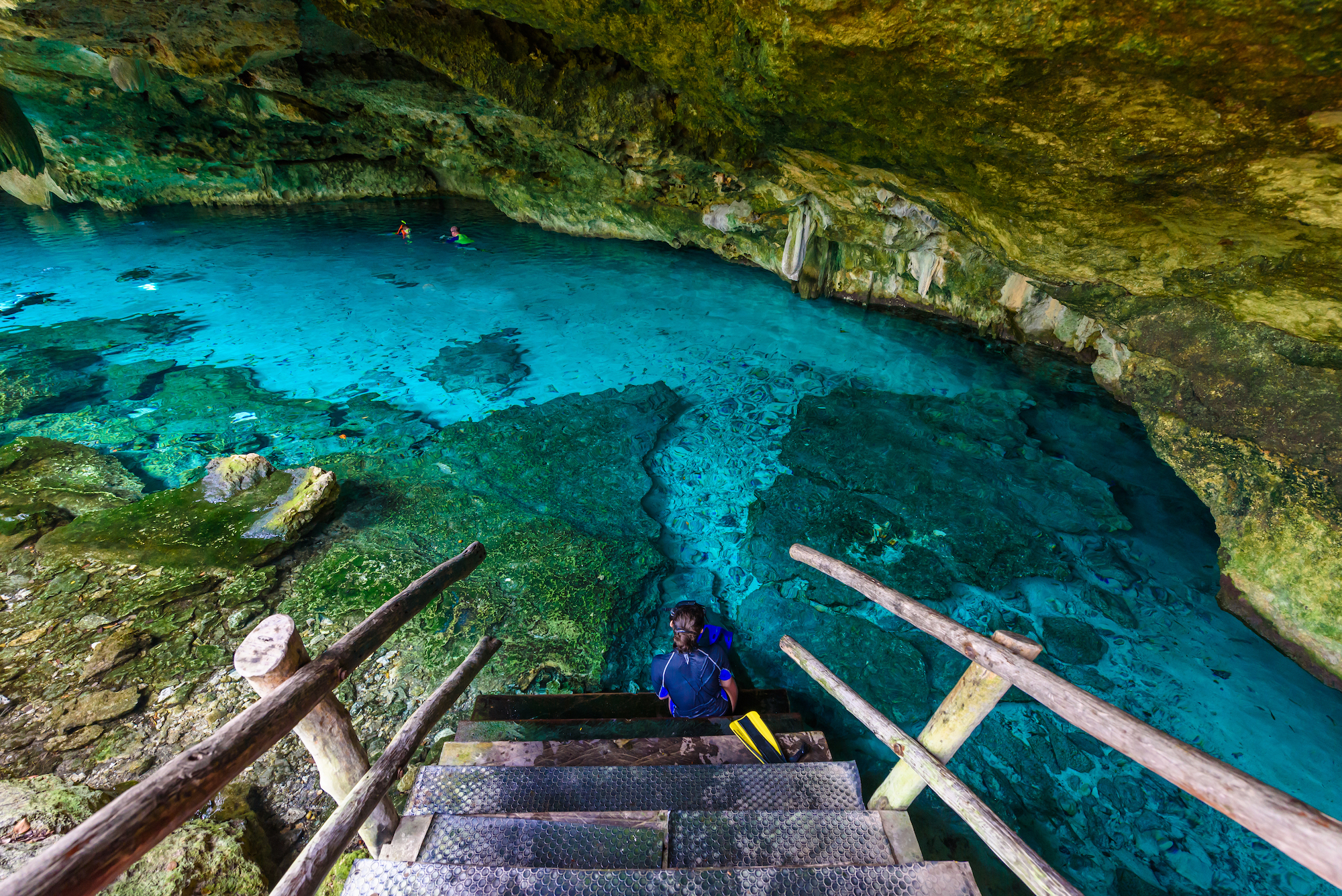 A freediver preparing to enter the Dos Ojos cenote in Mexico, where you can find crystal clear water and breathtaking scenery
