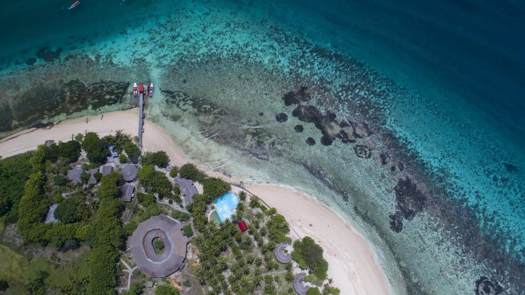 An aerial shot of the pool and beach at gangga island resort and spa in sulawesi indonesia