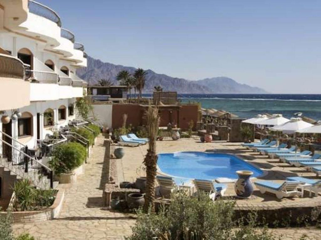The pool and accommodation along the shore the Red Sea at the Coral Coast Hotel in Dahab Egypt