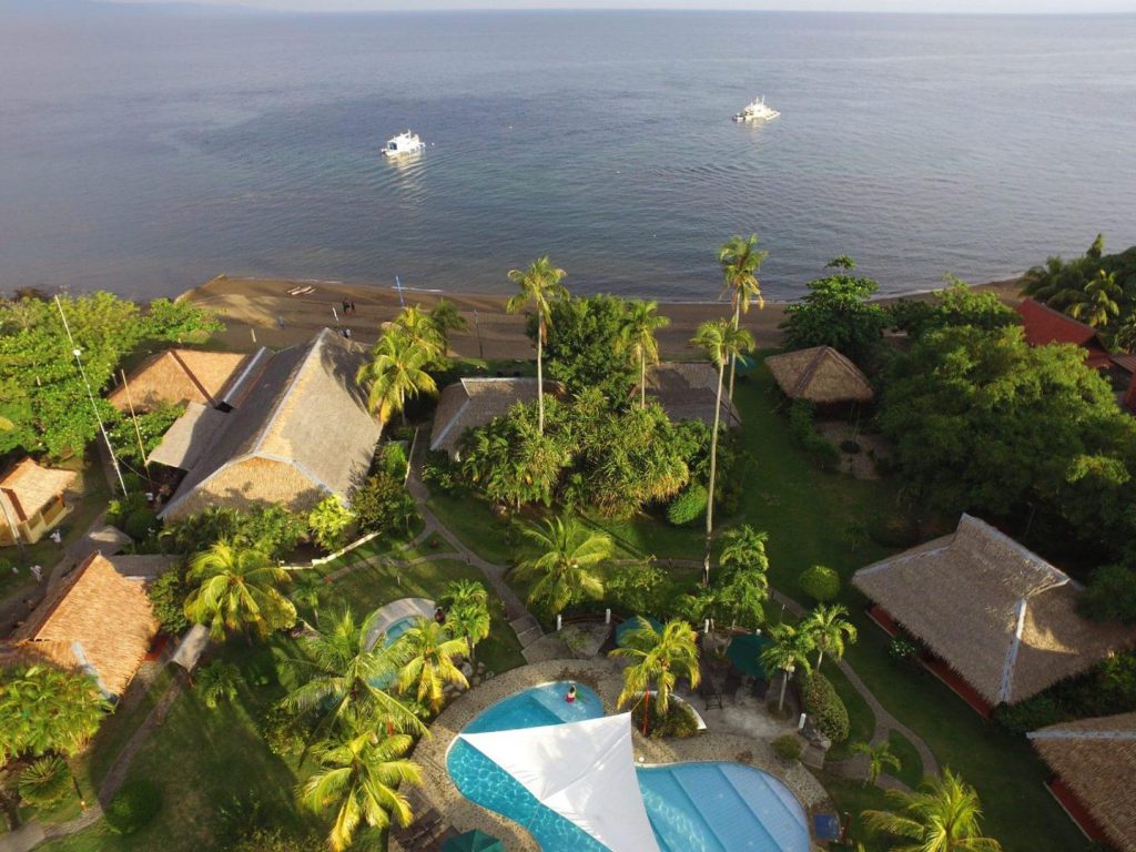 An aerial view of the pool and beach at the fish unlimited beach and dive resort in Dumaguete Dauin Philippines