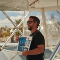 A PADI Pro delivers a dive briefing on a boat before a dive