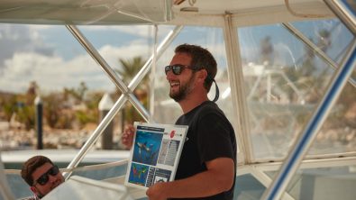 A PADI Pro delivers a dive briefing on a boat before a dive