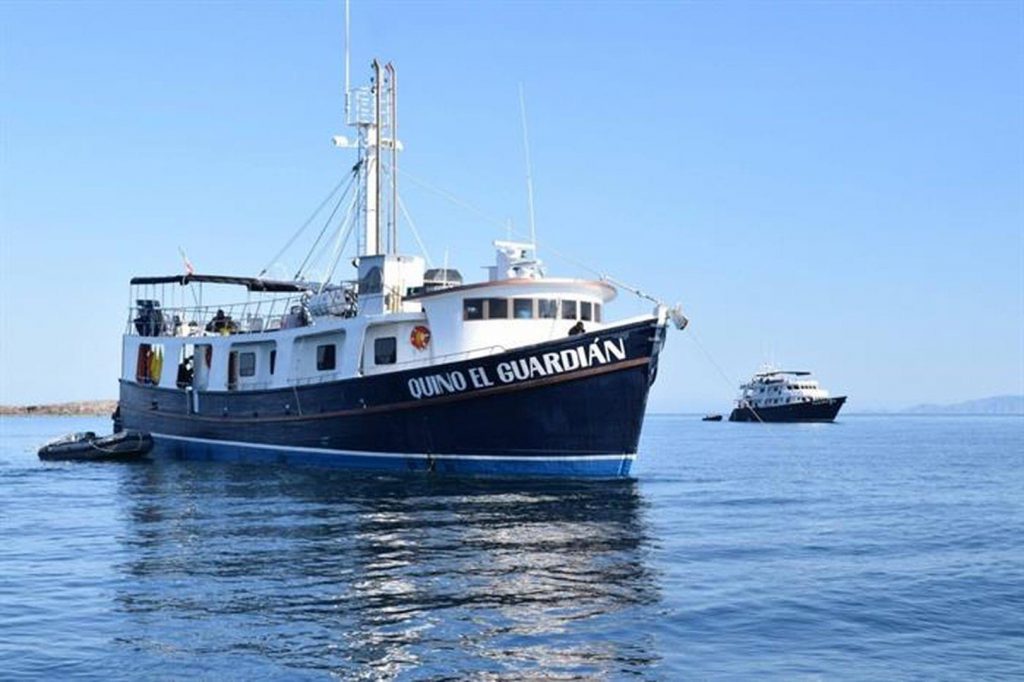 The Quino El Guardian Liveaboard on the water with a tender attached and blue skies all around