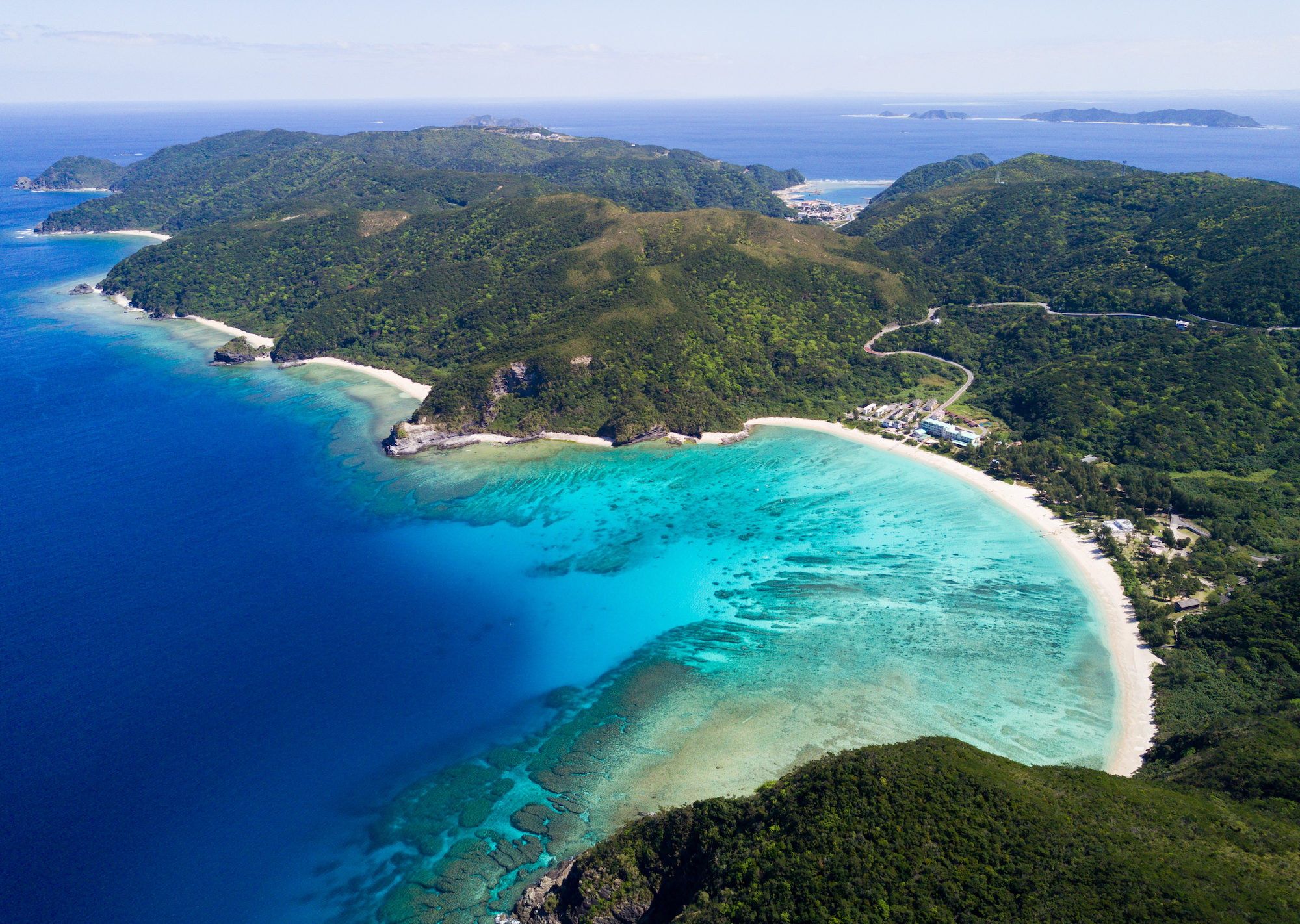 A topside aerial view of the white sands and blue water around Okinawa, Japan, one of the best shore diving destinations