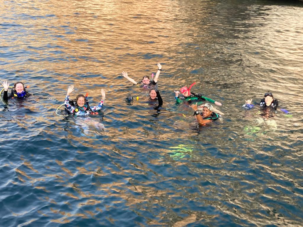 divers surface after a women's dive day event in oman