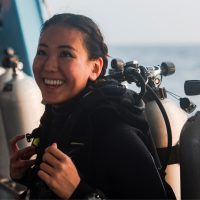 AmbassaDiver smiling on the boat in her dive gear.