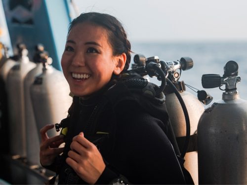 AmbassaDiver smiling on the boat in her dive gear.