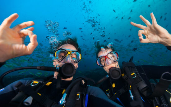 Two happy divers give the okay sign