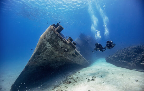 two scuba divers and a shipwreck in Grand Cayman