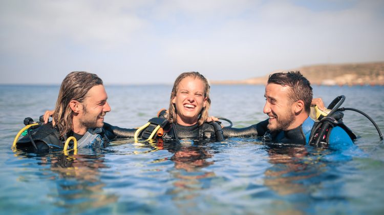 three scuba divers at the surface