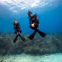 Two divers demonstrate excellent underwater buoyancy
