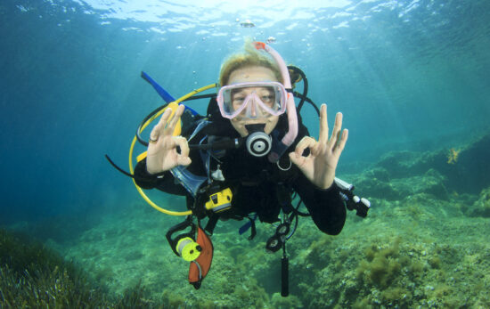 A teenage diver signals okay