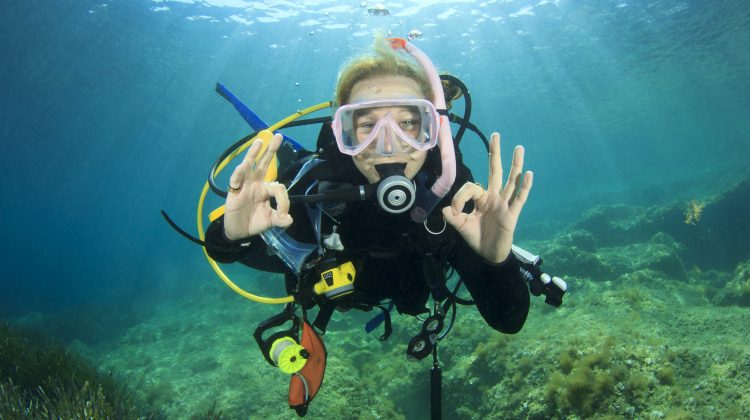 A teenage diver signals okay