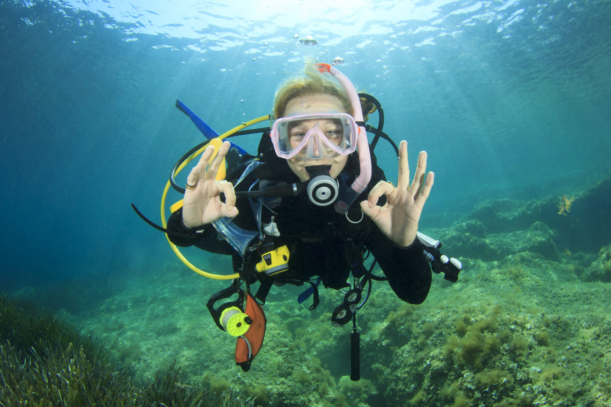 A teenage diver signals okay