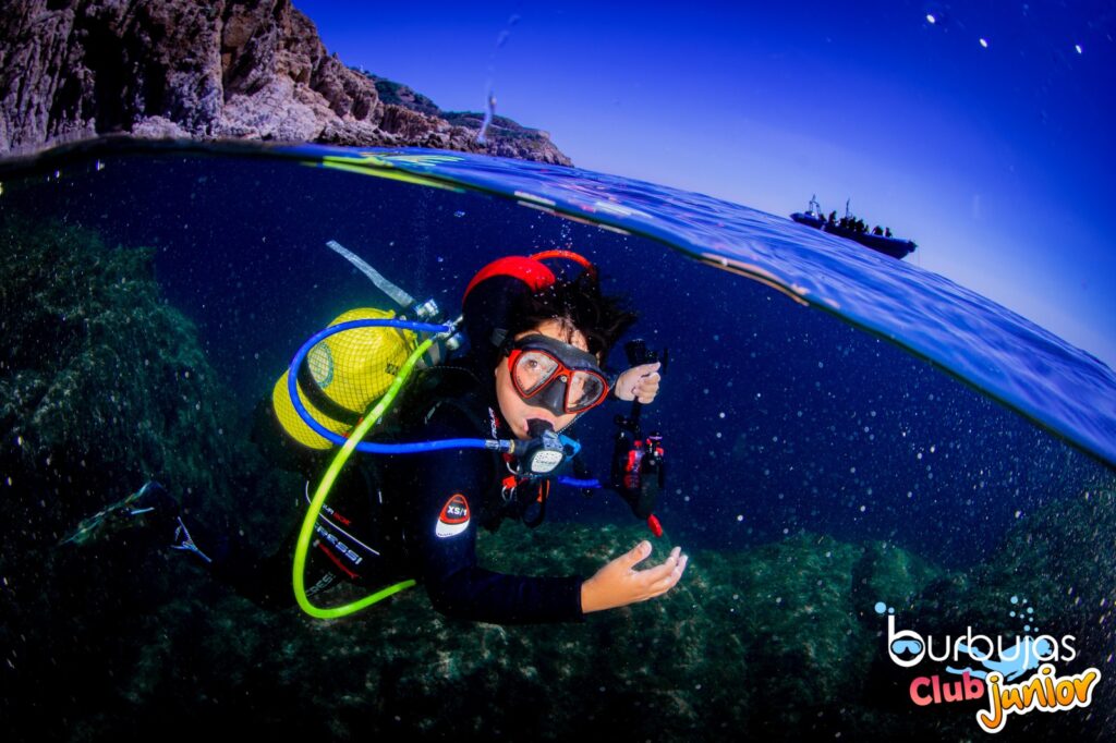 A junior scuba diver in Ceuta Spain in north africa holds an underwater camera